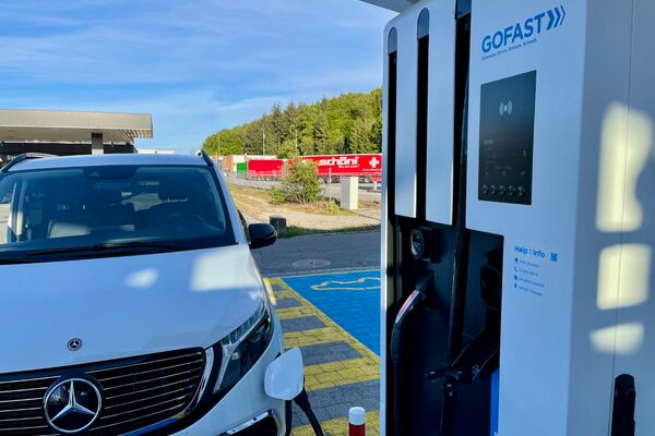la photo d’une voiture stationnée devant une borne de recharge électrique