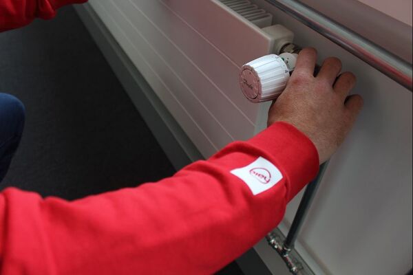 Photo d’un installateur de chez Hälg, remplaçant un thermostat