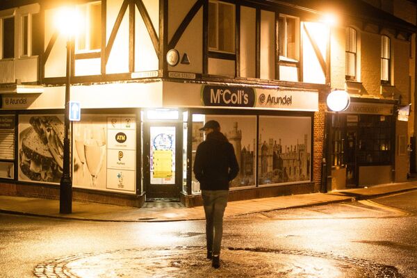 Éclairage public nocturne d’une rue avec un passant