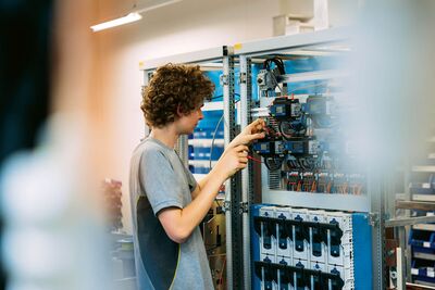 Un électricien réalise le câblage de contrôleurs pour l’automation du bâtiment