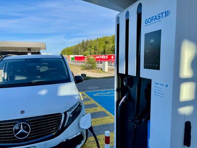 la photo d’une voiture stationnée devant une borne de recharge électrique